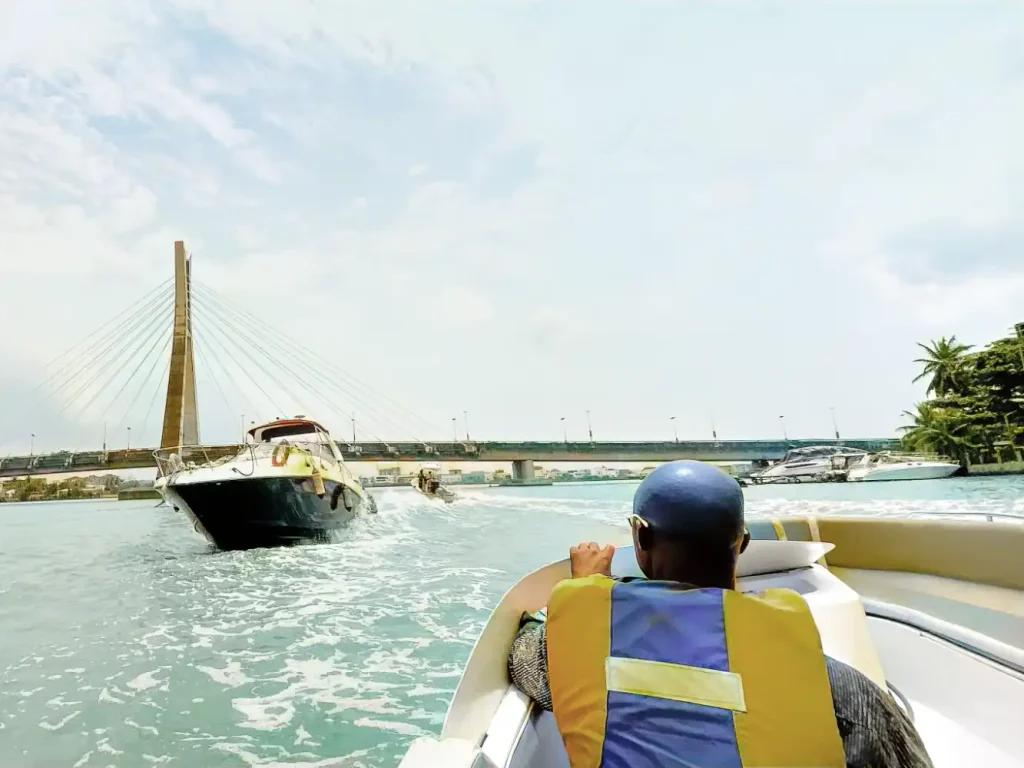 The Ultimate Lagos Date Guide: Discover 10 Memorable Ways To Connect 3 Boats cruising on Lagos Lagoon beside the Lekki–Ikoyi Link Bridge, lagos date ideas, the wheatbaker,