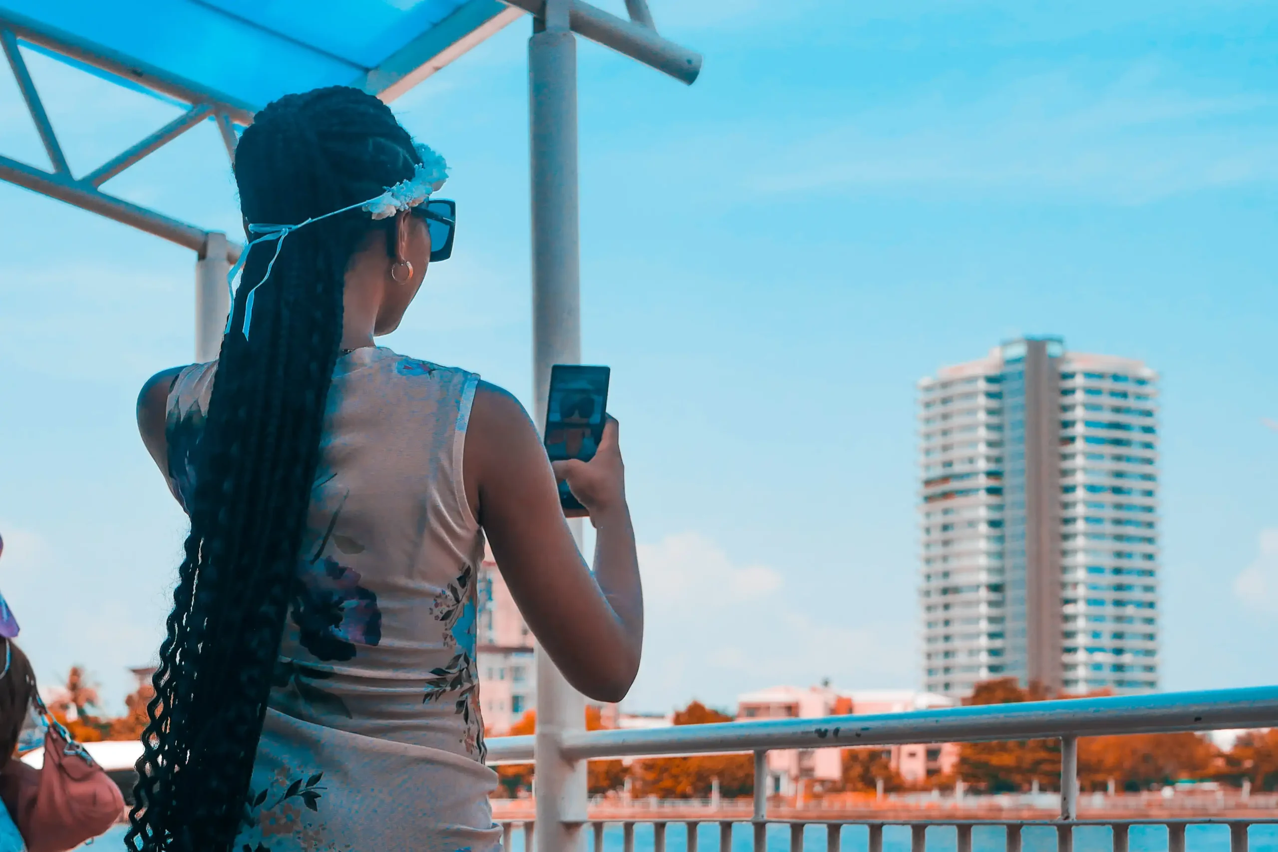 Woman taking a photograph beside the water at a Lagos jetty
